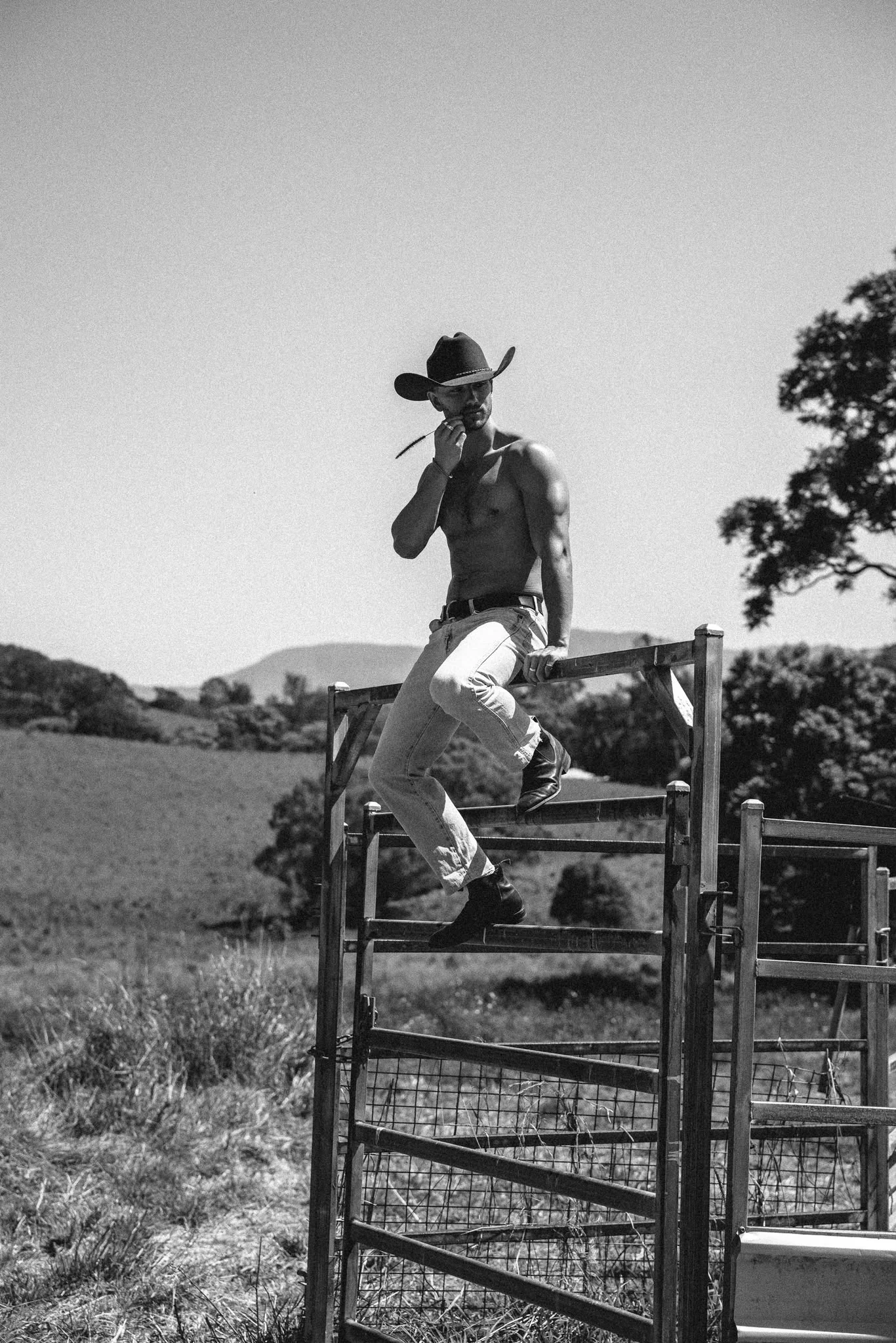 Black and white cowboy portrait on a farm gate