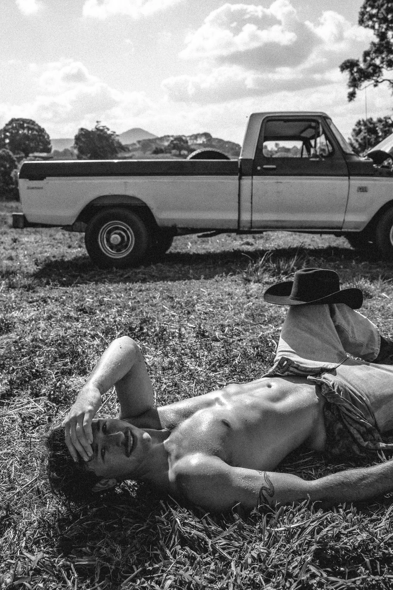Black and white cowboy portrait near a ute